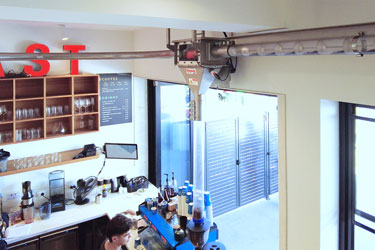 Visible Conveying of Freshly Roasted Beans Creates Unique Customer Experience at Merlo Coffee